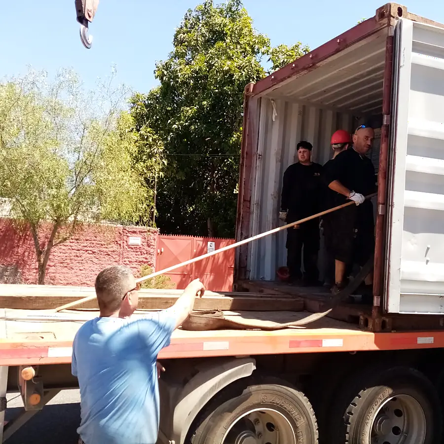Riggers abriendo un contenedor sobre camión para iniciar la descarga