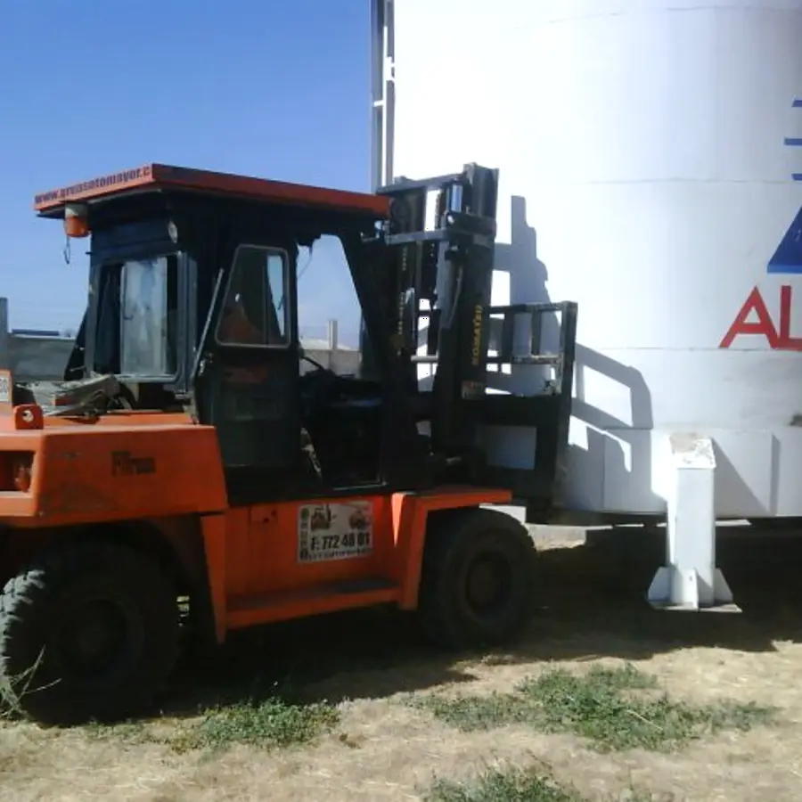 Grúa horquilla de alto tonelaje junto a un estanque industrial
